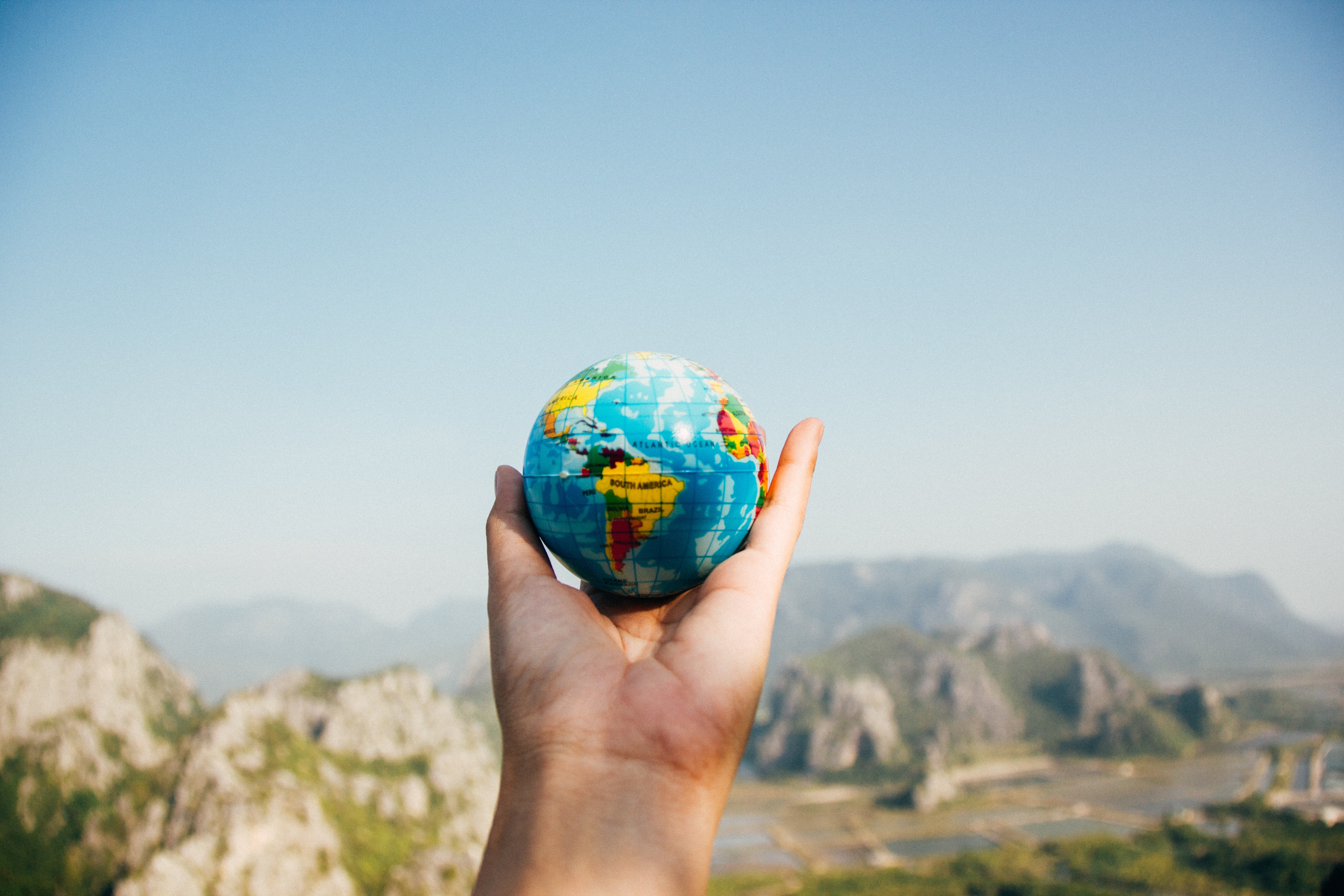 person holding world globe in their hand